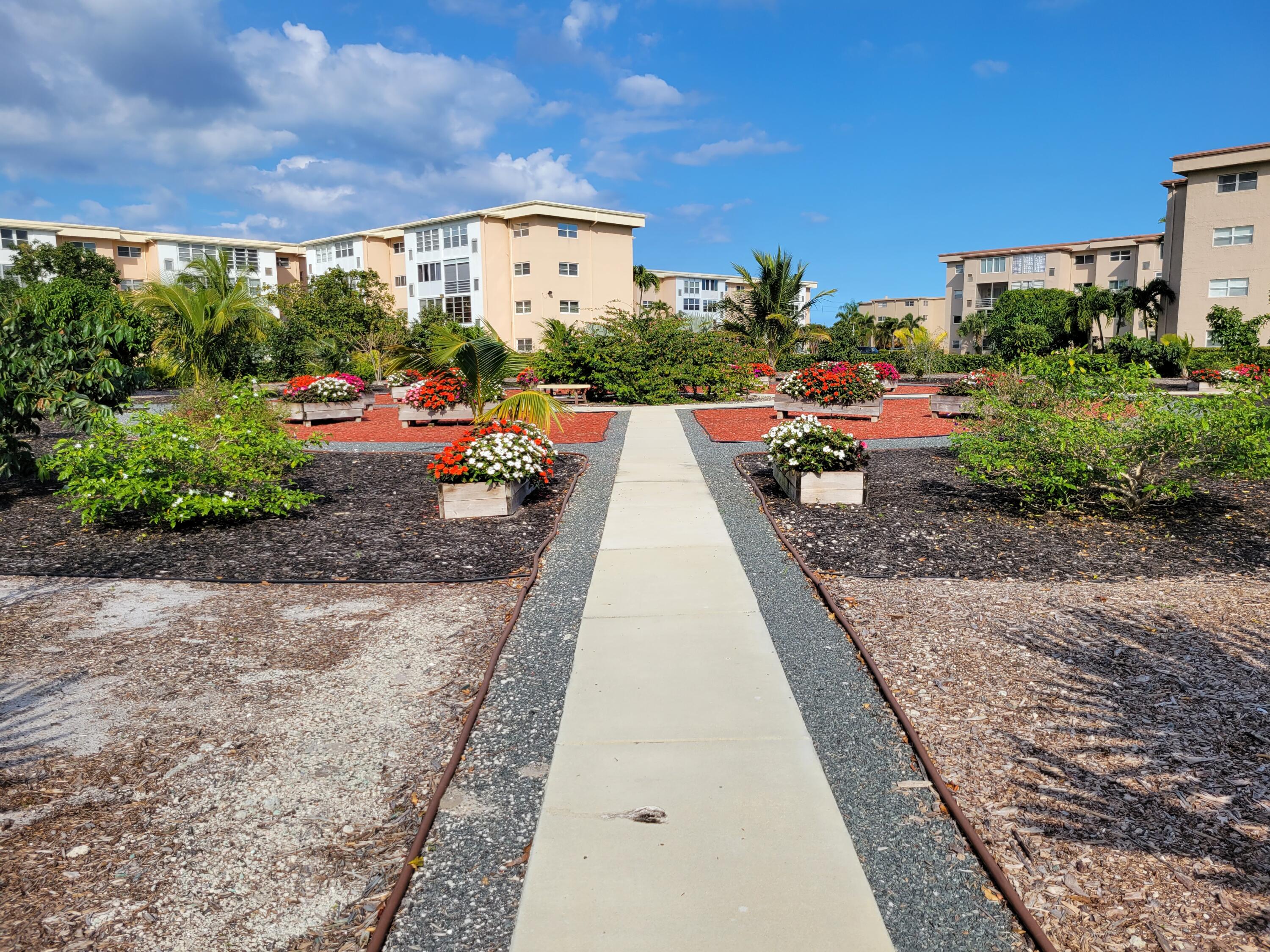 300 Northeast 26th Avenue, Unit 305 Boynton Beach, FL 33435 - Photo 36 of 54 a view of a patio with a table and chairs under an umbrella