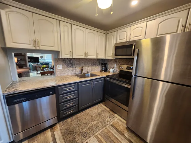 a kitchen with stainless steel appliances granite countertop a refrigerator sink and cabinets