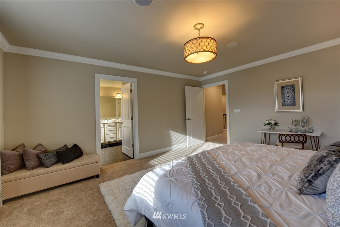 4130 174th Street Southeast Bothell, WA 98012 - Photo 18 of 29 a bedroom with a bed and a chandelier