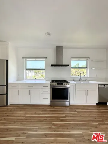 a kitchen with stainless steel appliances kitchen island granite countertop a stove a sink and a microwave