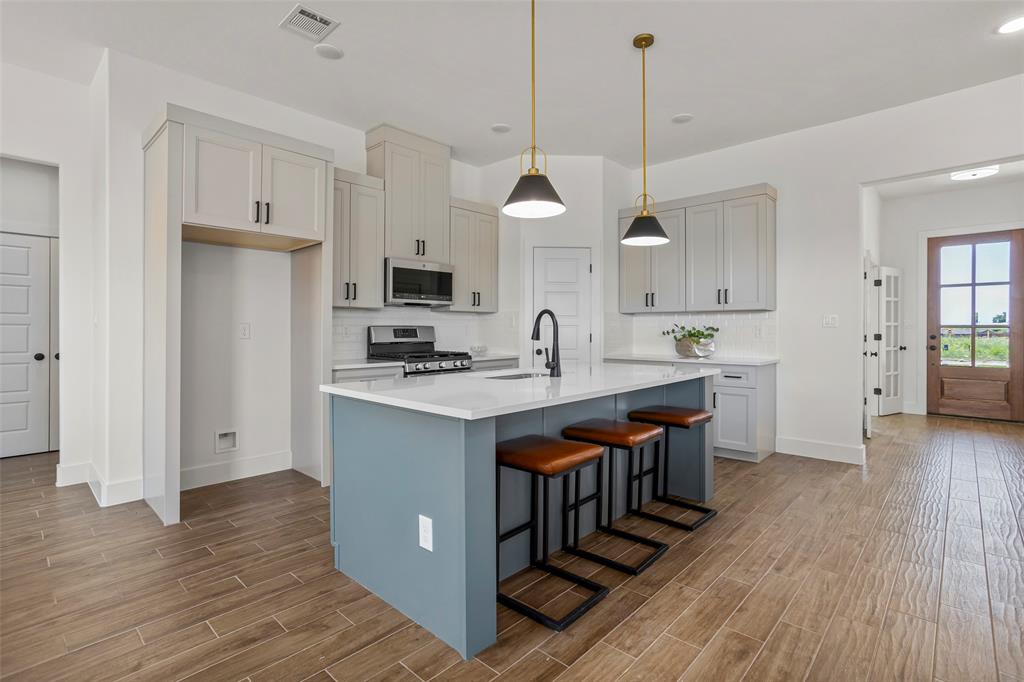 204 Cliff Court Godley, TX 76044 - Photo 9 of 27 a kitchen with kitchen island granite countertop a sink a counter top space stainless steel appliances and cabinets