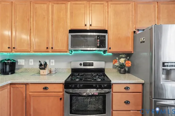 a kitchen with stainless steel appliances granite countertop a stove a sink and a microwave