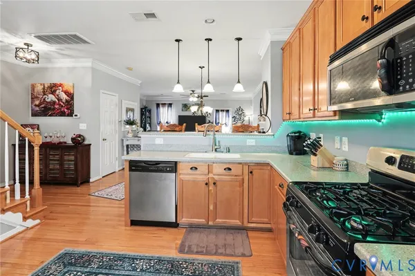a kitchen with stainless steel appliances granite countertop a stove a refrigerator a oven and a sink with cabinets