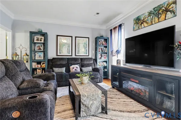 a view of a dining room and livingroom with furniture wooden floor a chandelier