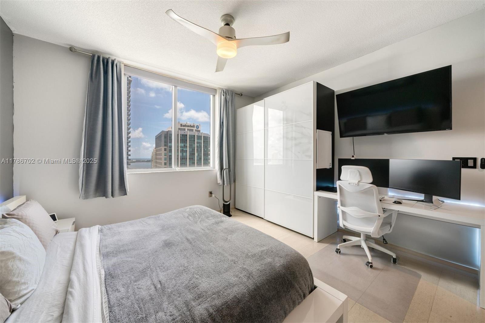 1060 Brickell Avenue, Unit 3003 Miami, FL 33131 - Photo 13 of 39 a bedroom with a bed and a flat screen tv