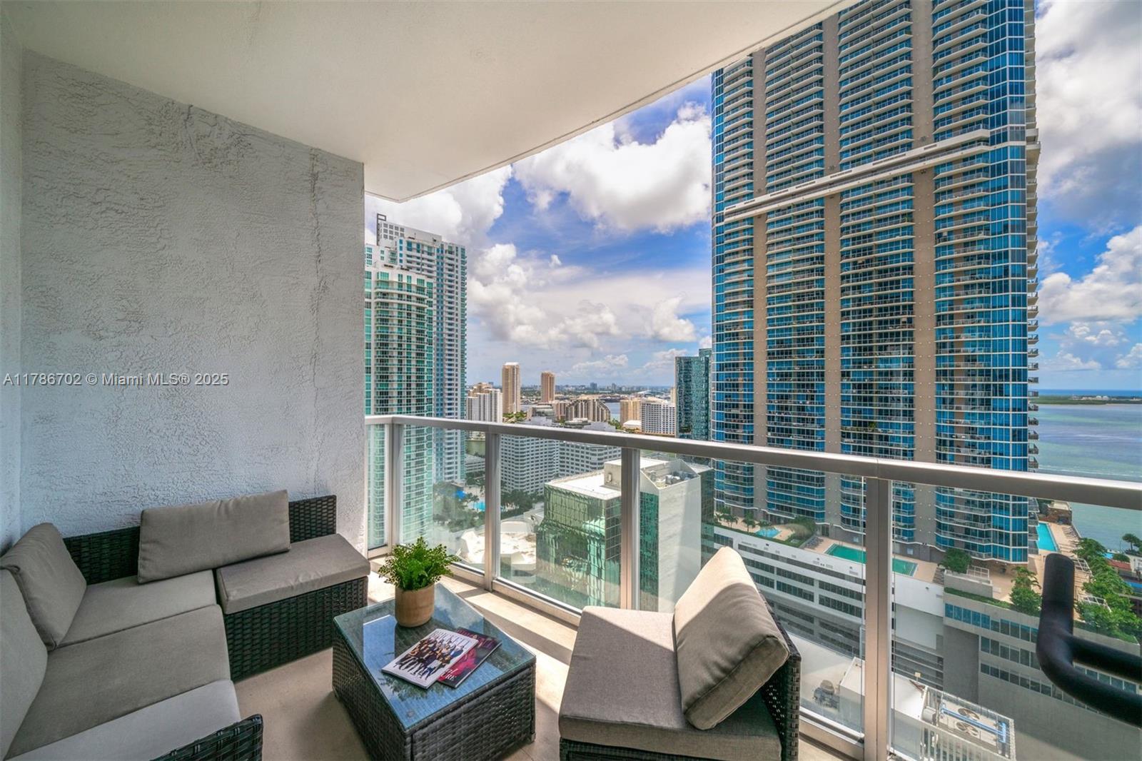 1060 Brickell Avenue, Unit 3003 Miami, FL 33131 - Photo 18 of 39 a balcony with furniture and a book shelf