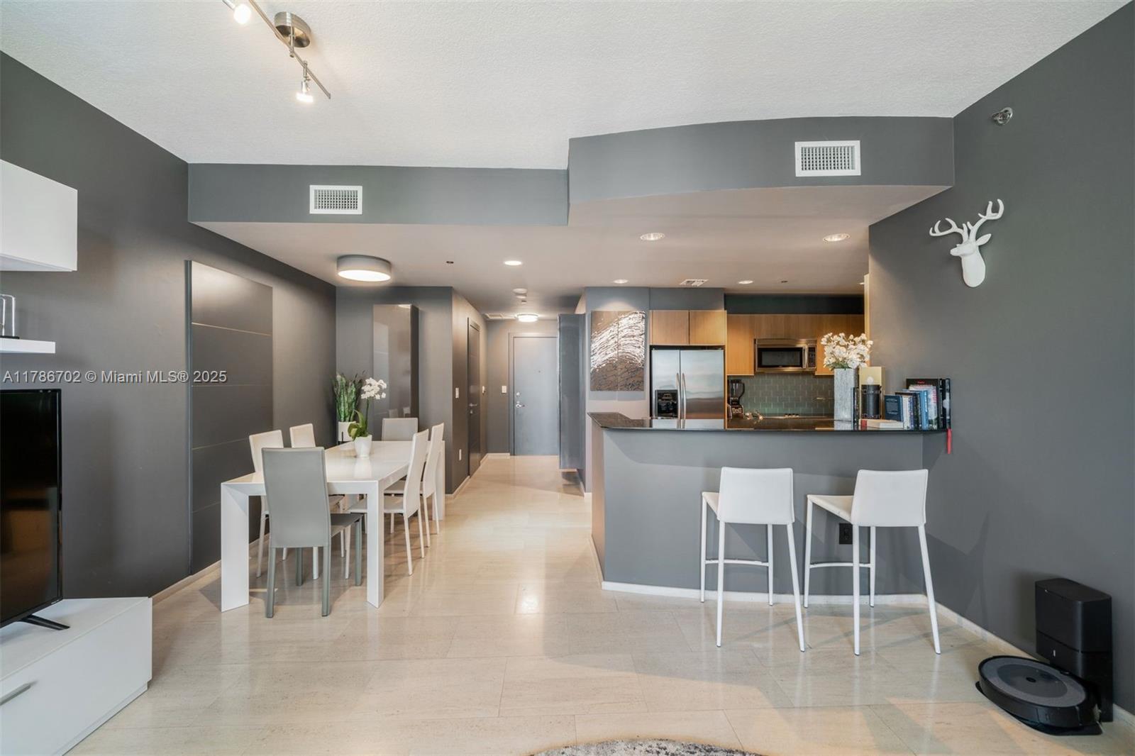 1060 Brickell Avenue, Unit 3003 Miami, FL 33131 - Photo 5 of 39 a dining area with stainless steel appliances a dining table chairs and view kitchen