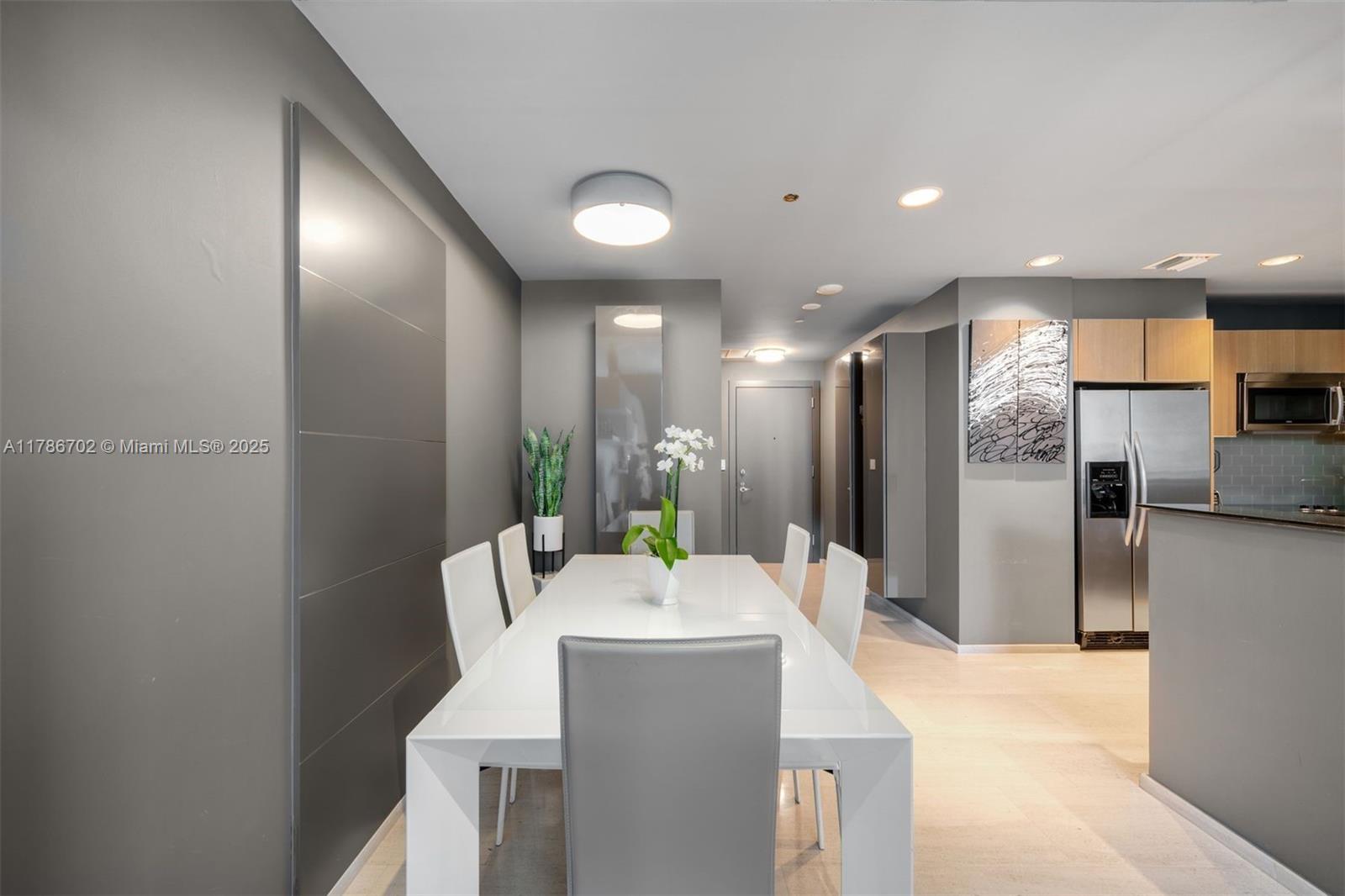 1060 Brickell Avenue, Unit 3003 Miami, FL 33131 - Photo 6 of 39 a kitchen with stainless steel appliances a refrigerator and a dining table