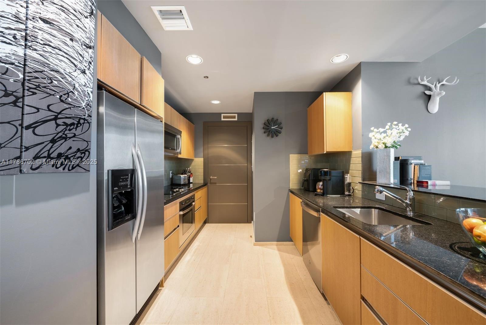 1060 Brickell Avenue, Unit 3003 Miami, FL 33131 - Photo 7 of 39 a large kitchen with granite countertop a large counter top appliances and cabinets