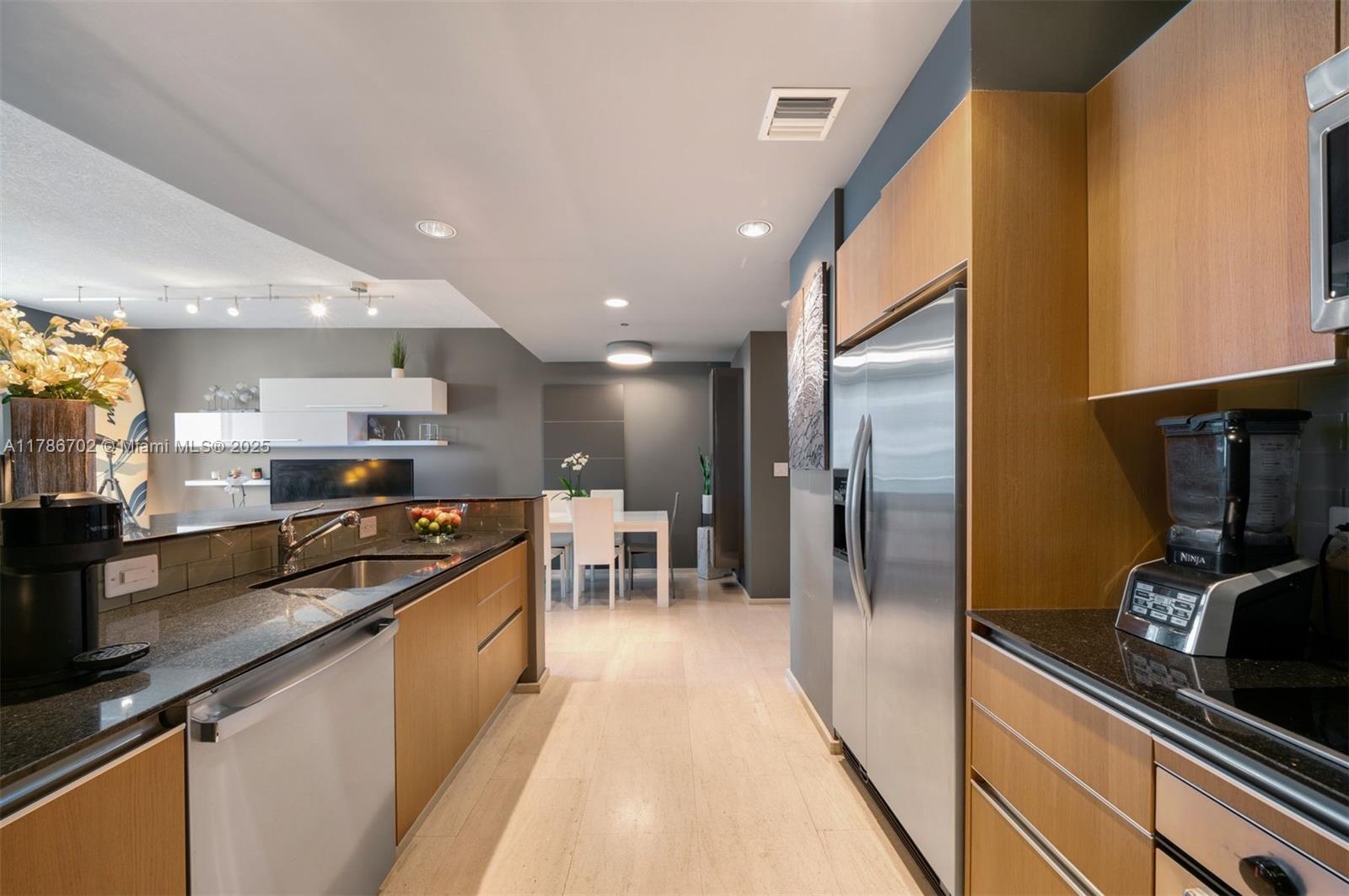 1060 Brickell Avenue, Unit 3003 Miami, FL 33131 - Photo 9 of 39 a kitchen with stainless steel appliances granite countertop a stove a sink and a refrigerator
