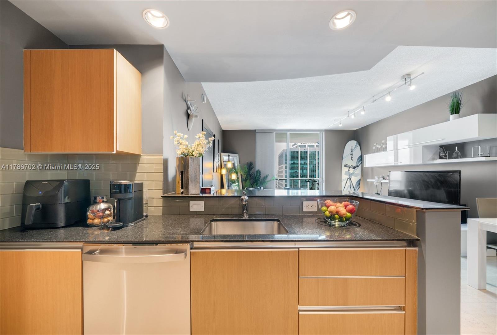 1060 Brickell Avenue, Unit 3003 Miami, FL 33131 - Photo 10 of 39 a kitchen with stainless steel appliances granite countertop a sink a stove and a refrigerator