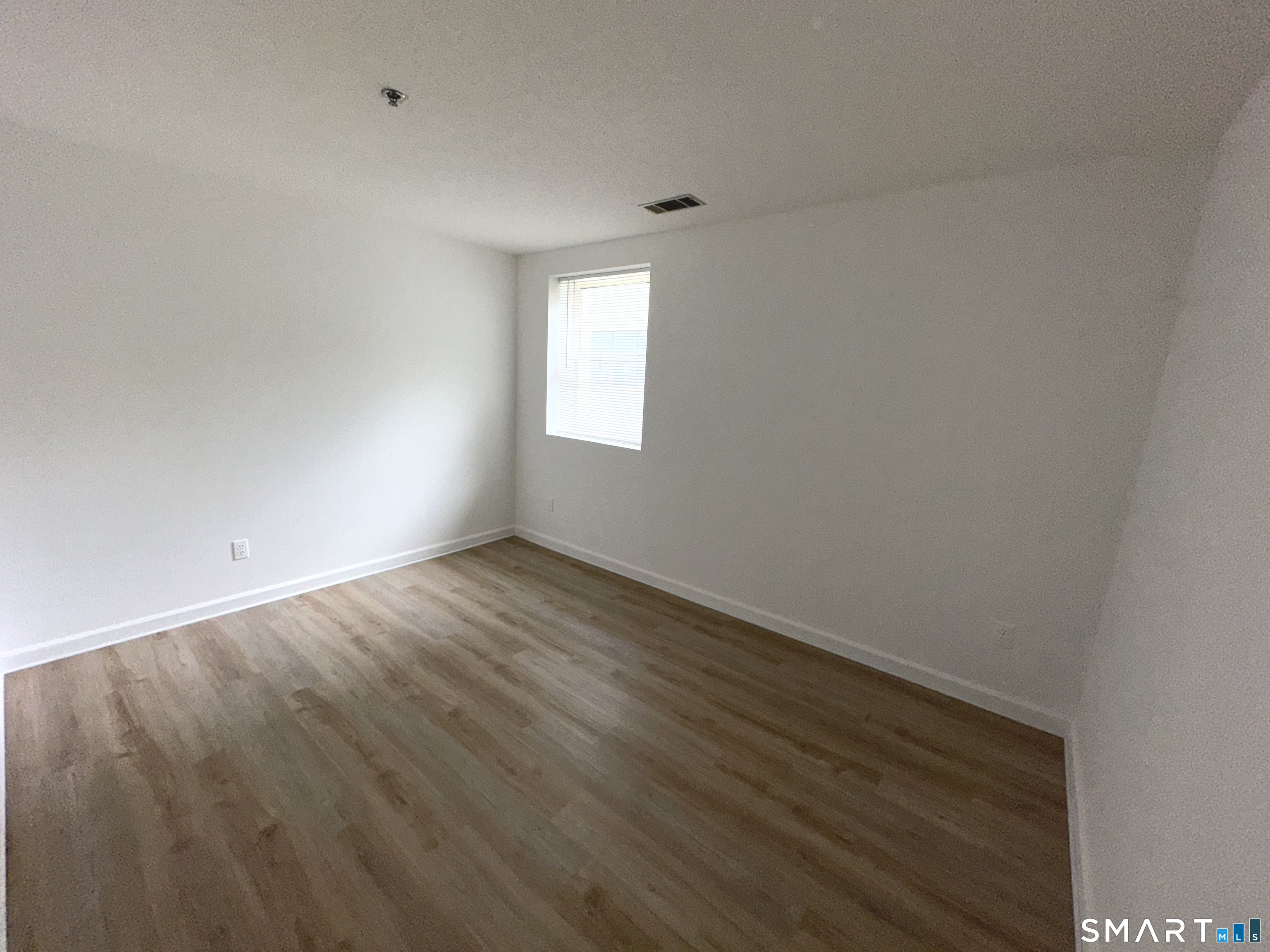 243 Judd Square, Unit 243 Wallingford, CT 06492 - Photo 11 of 17 an empty room with wooden floor and windows