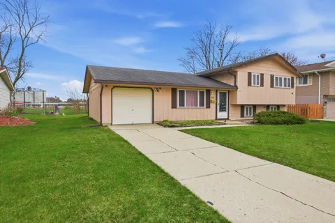 a front view of a house with a yard and trees
