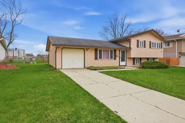a front view of a house with a yard and trees