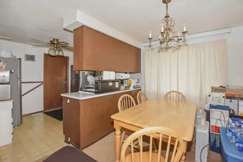 a dining room with furniture a chandelier and window