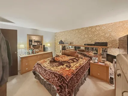 a bed sitting in a room next to a lamp next to a window