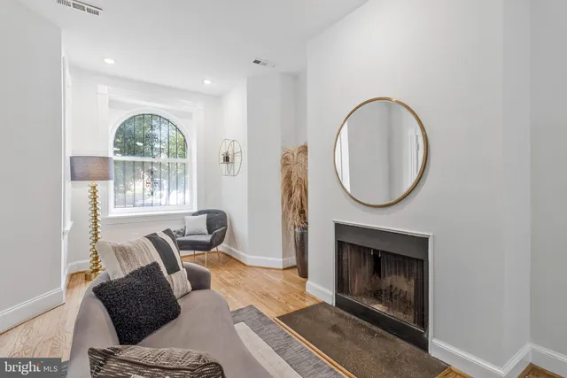 a living room with furniture a mirror and a fireplace