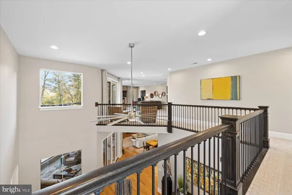 a bedroom with a bed painting on wall and two windows