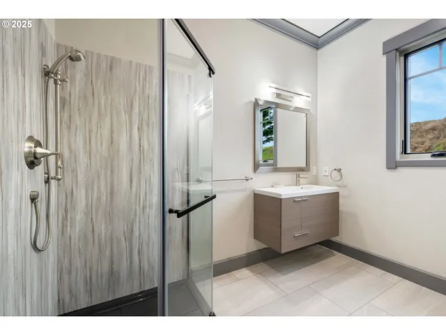 a bathroom with a double vanity sink mirror and shower