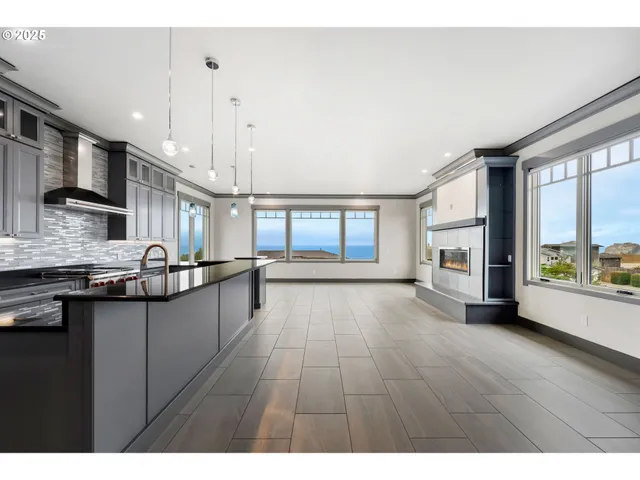 a open kitchen with granite countertop a stove top oven a sink a counter space and cabinets