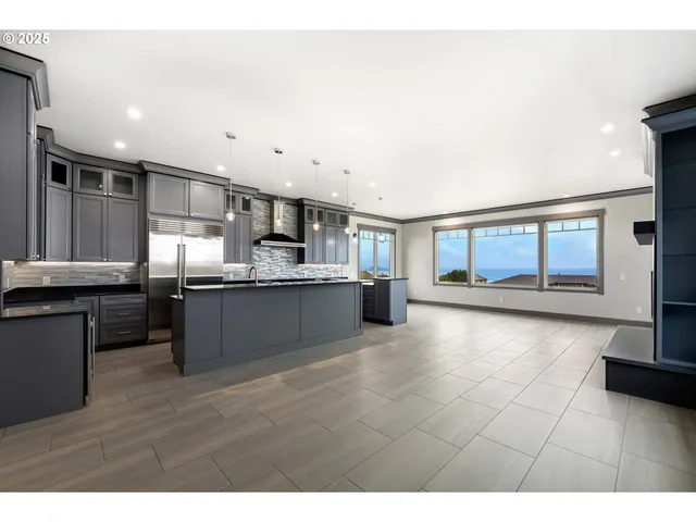 a large kitchen with a large counter top stainless steel appliances and cabinets