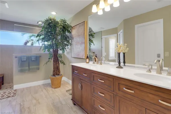 a spacious bathroom with a granite countertop sink a mirror and a shower
