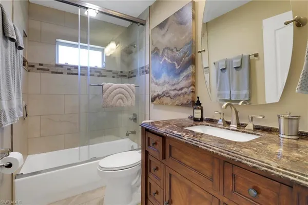 a bathroom with a granite countertop sink toilet and shower