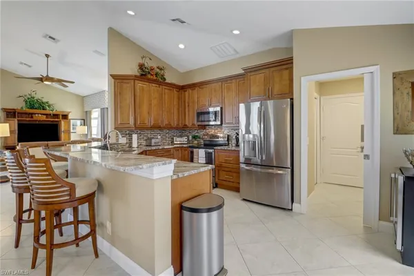 a kitchen with stainless steel appliances granite countertop a refrigerator a stove a sink and a microwave