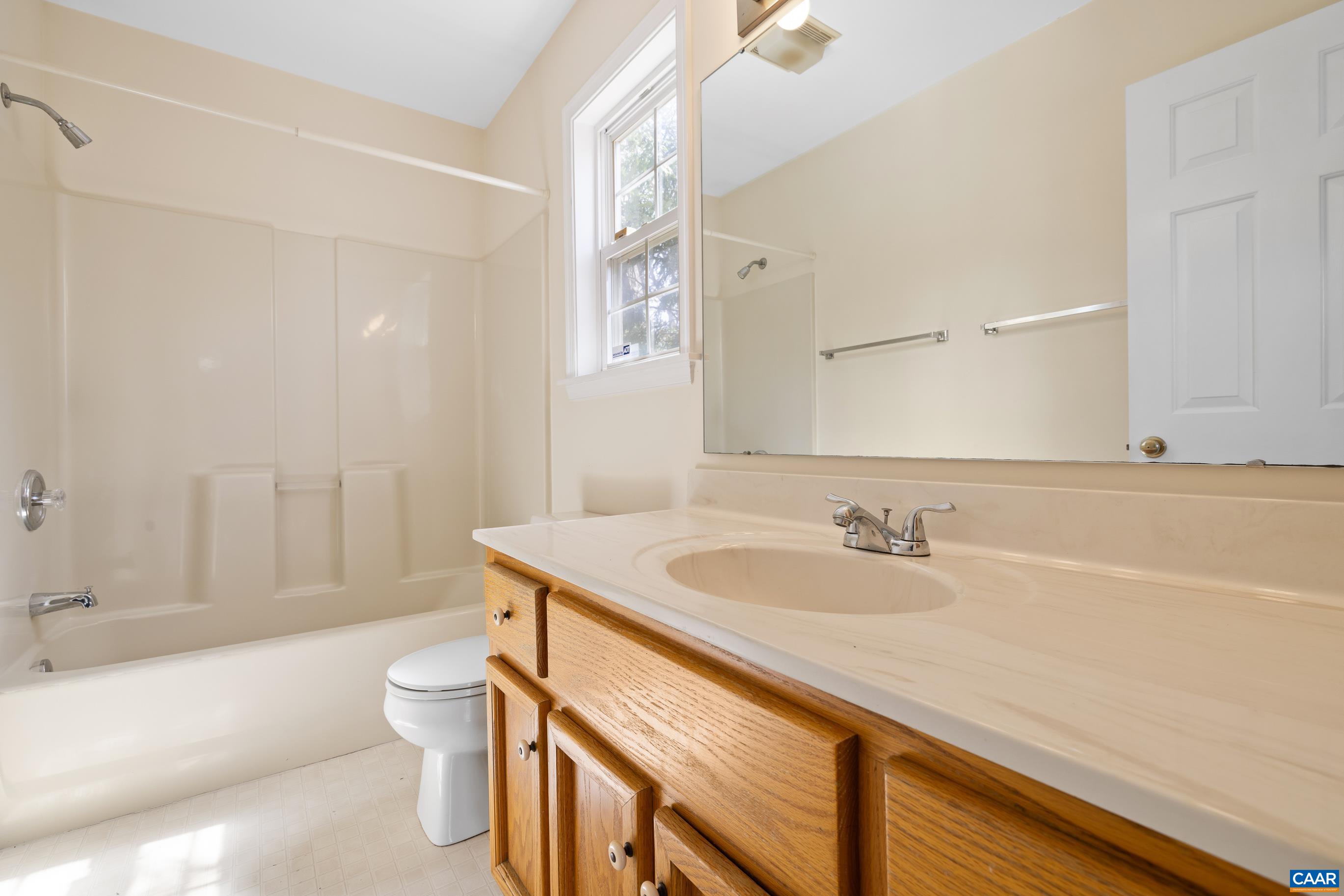 3041 Copper Knoll Road Charlottesville, VA 22911 - Photo 18 of 30 a bathroom with a granite countertop sink a toilet a mirror and bathtub