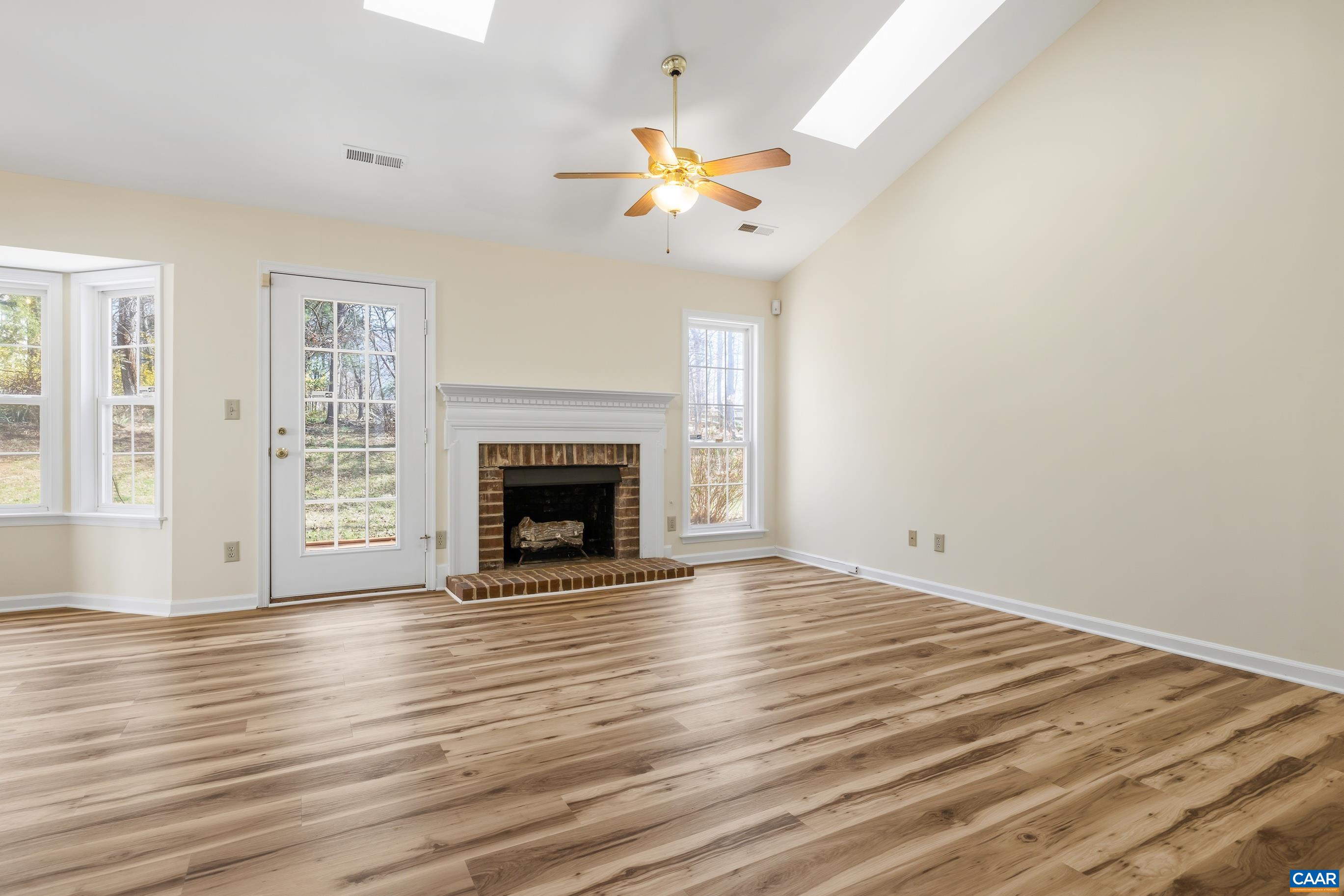 3041 Copper Knoll Road Charlottesville, VA 22911 - Photo 4 of 30 a view of an empty room with wooden floor fireplace and a window
