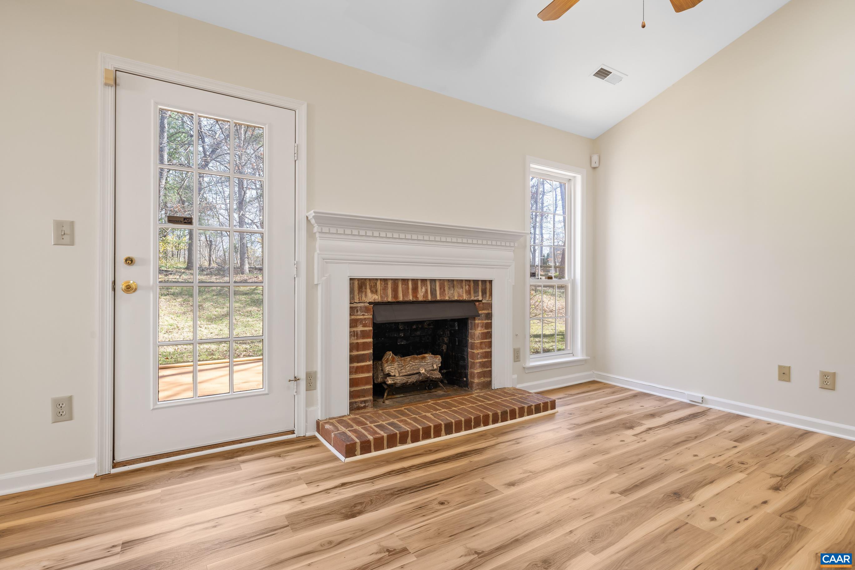 3041 Copper Knoll Road Charlottesville, VA 22911 - Photo 7 of 30 a view of an empty room with wooden floor fireplace and a window
