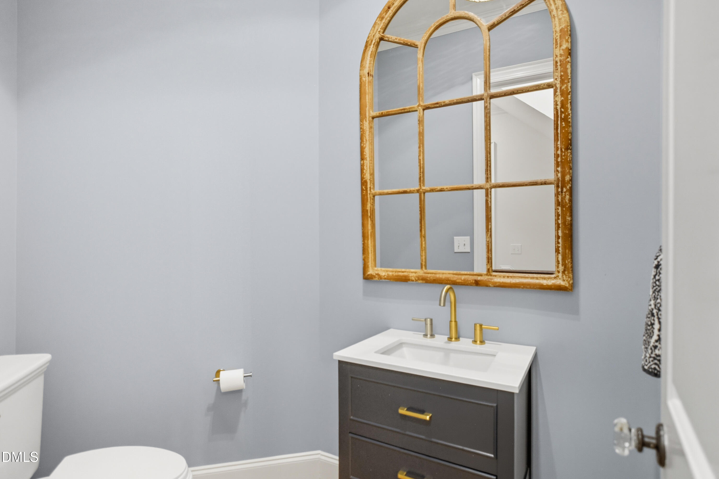 1409 Caistor Lane Raleigh, NC 27614 - Photo 16 of 46 a bathroom with a toilet sink vanity and mirror