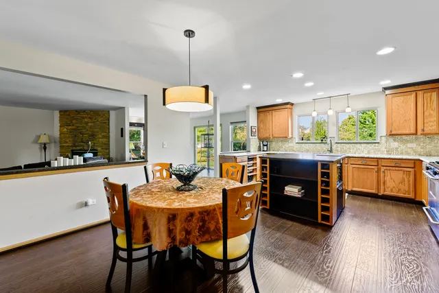 a kitchen with a stove a sink a dining table and chairs
