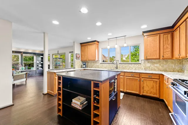 a kitchen with stainless steel appliances granite countertop sink stove and wooden cabinets