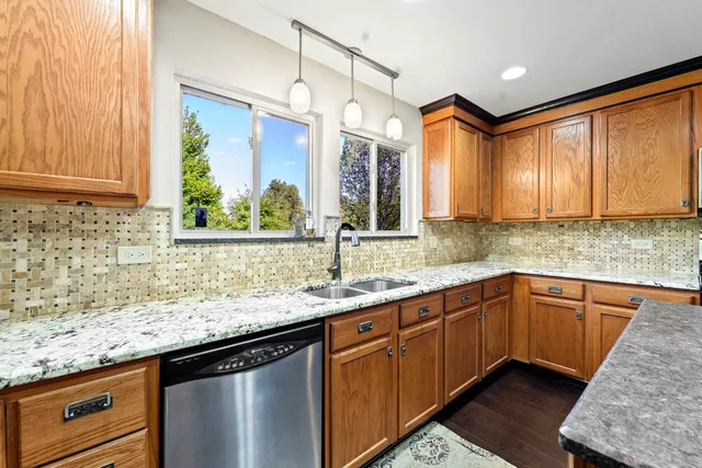 a kitchen with stainless steel appliances granite countertop cabinets sink and large window