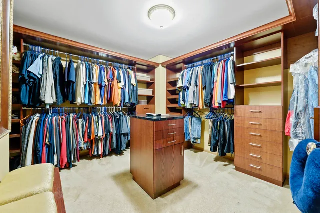 a view of walk in closet with clothes and shoes