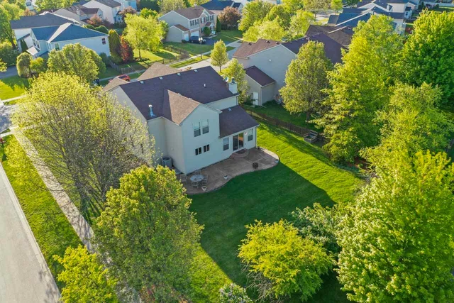 an aerial view of residential house with outdoor space and trees all around