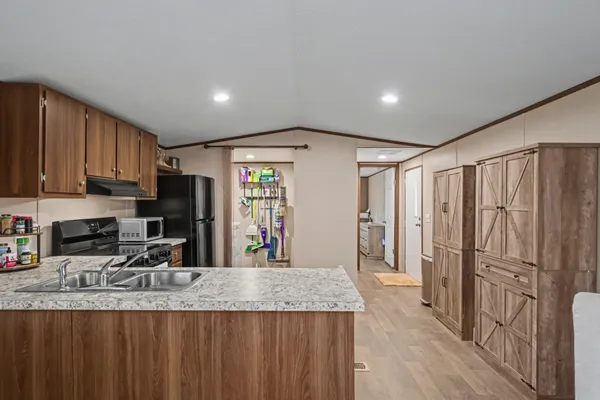 a kitchen with stainless steel appliances granite countertop a sink refrigerator and cabinets