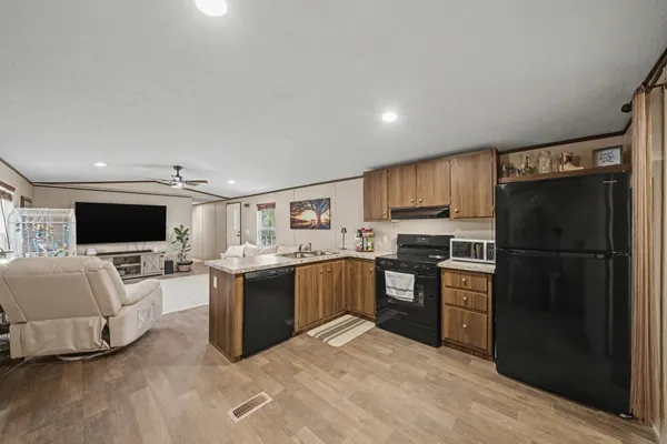 a large open kitchen with a refrigerator stove top oven and sink
