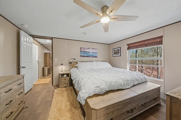 a spacious bedroom with a large bed and a chandelier