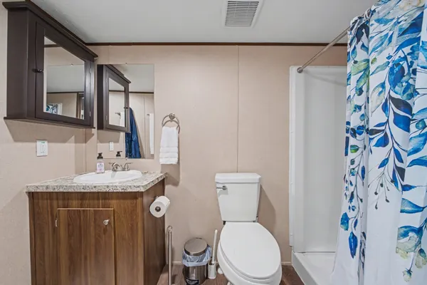 a bathroom with a granite countertop toilet sink and mirror