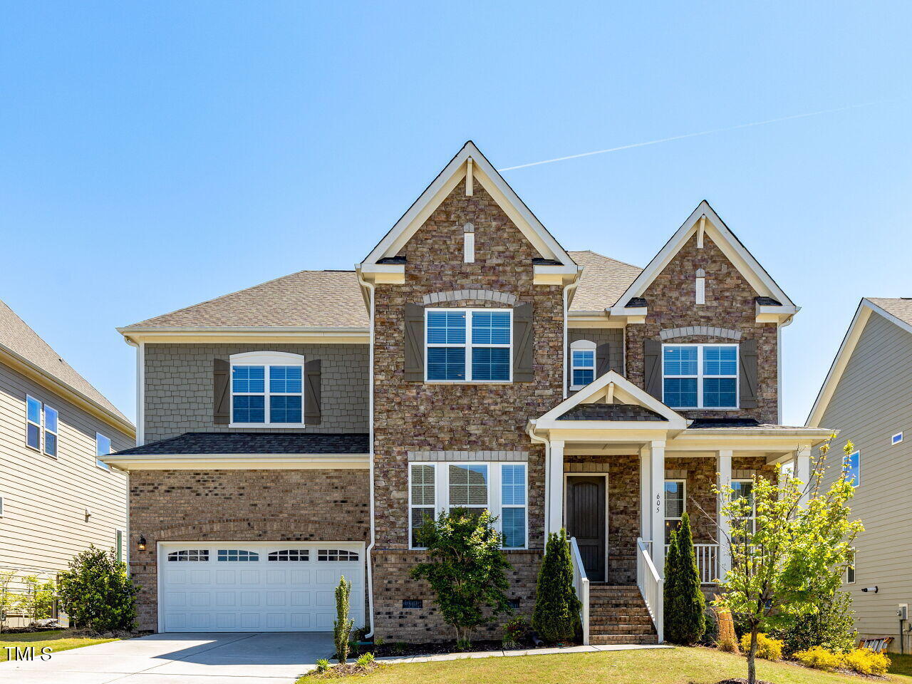 a front view of a house with a yard and garage