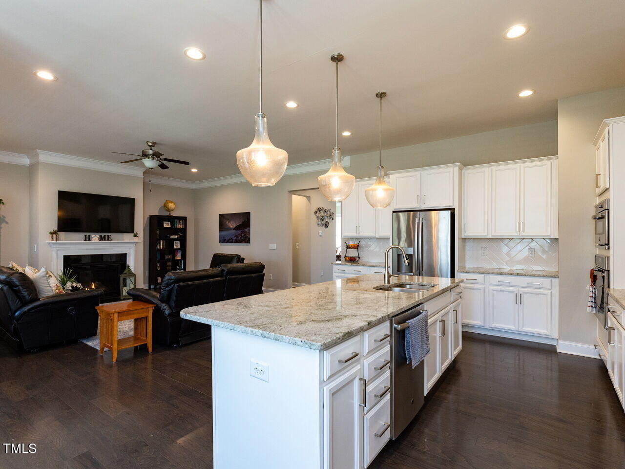 605 White Oak Pond Road Apex, NC 27523 - Photo 16 of 46 a large kitchen with kitchen island a stove a sink a oven a dining table and chairs