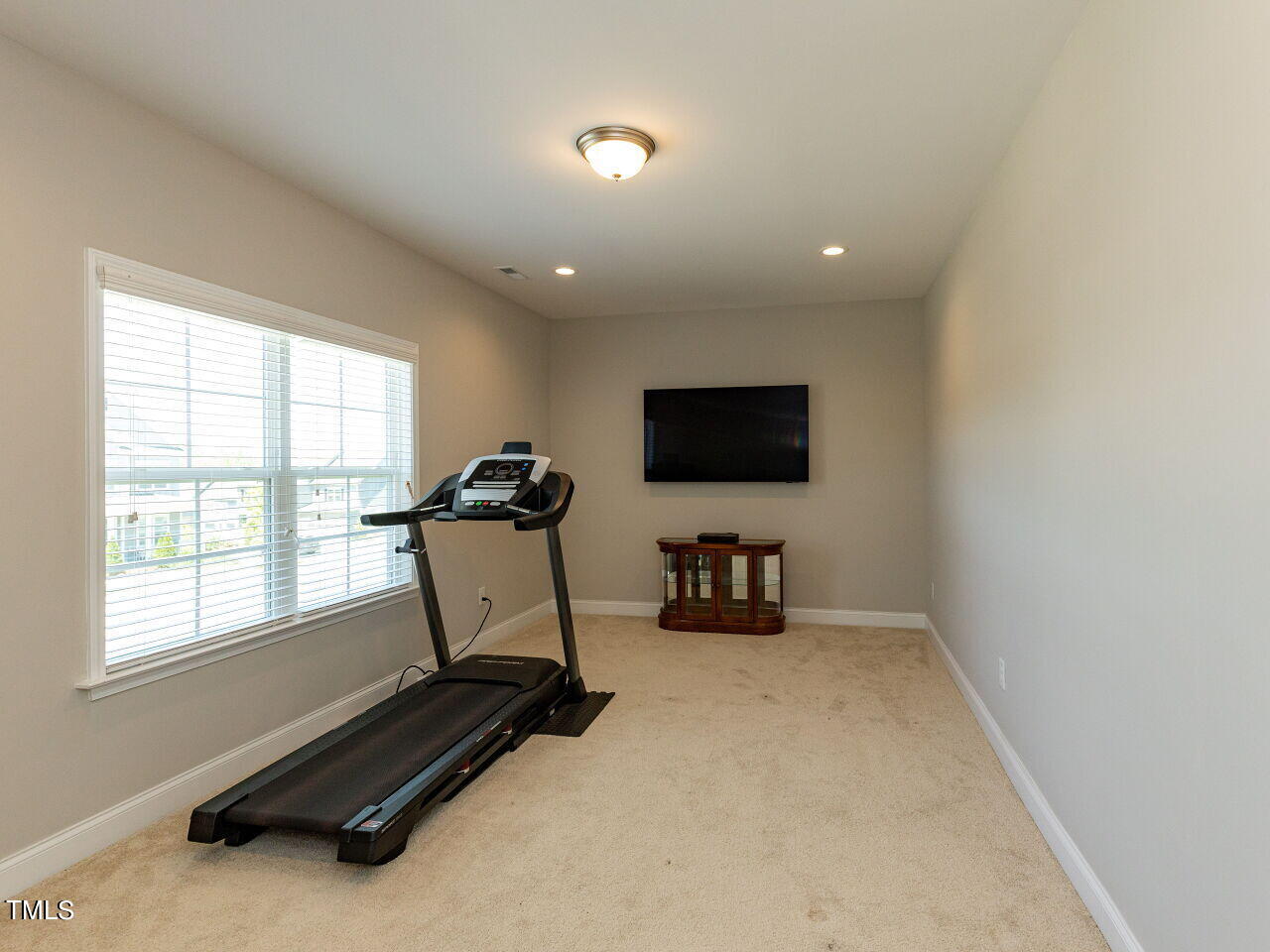 605 White Oak Pond Road Apex, NC 27523 - Photo 23 of 46 a room with gym equipment and a flat screen tv