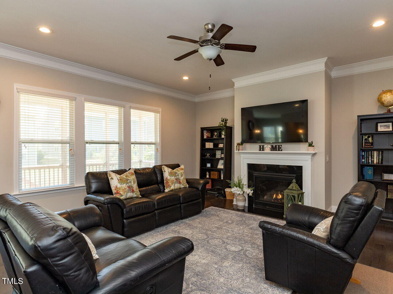605 White Oak Pond Road Apex, NC 27523 - Photo 10 of 46 a living room with furniture a fireplace and a flat screen tv