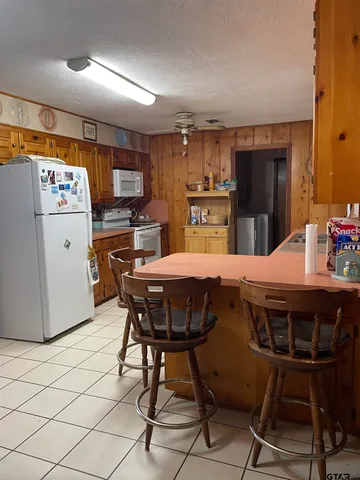 a kitchen with stainless steel appliances a dining table chairs refrigerator and sink