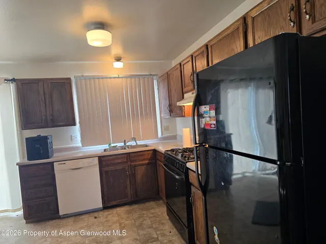 a kitchen with stainless steel appliances granite countertop a sink and a refrigerator
