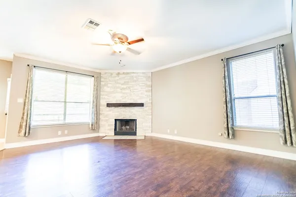 an empty room with windows and fireplace