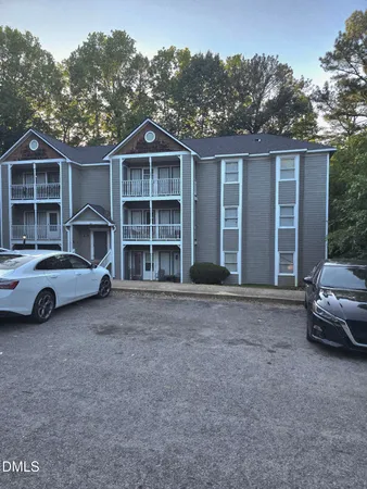 a view of a house with a yard and parking space