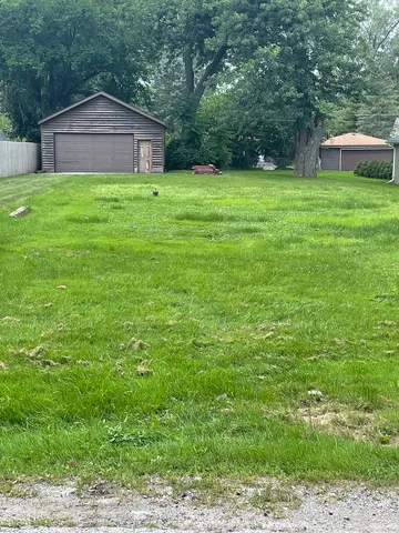a backyard of a house with plants and large trees